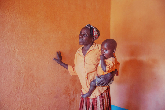 A homeowner gesturing toward the wall of her newly finished home